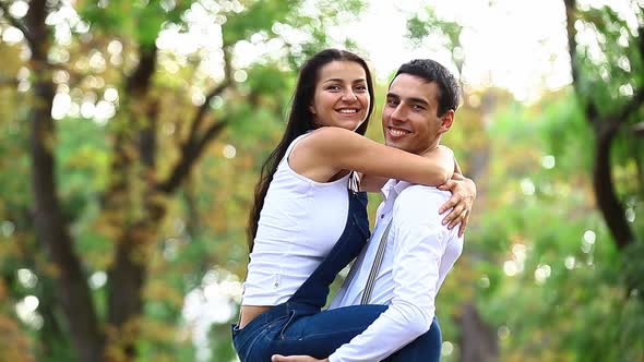 Teen couple hugging in the park in autumn time
