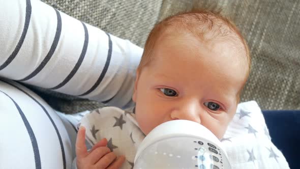 Newborn Caucasian Baby Boy Eating Milk from Bottle