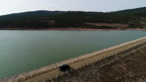 Driving Car On Road Along Lake alt