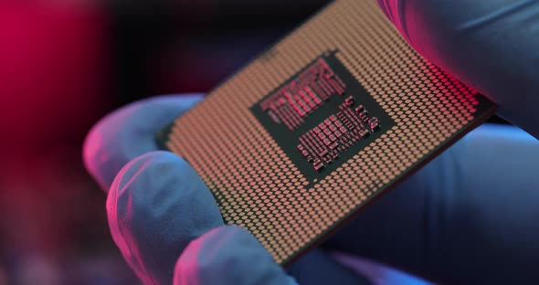 manipulating and installing processor on the motherboard in details with blur and selective focus alt