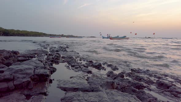 Small waves crash on the rocks on the western coast of mumbai alt