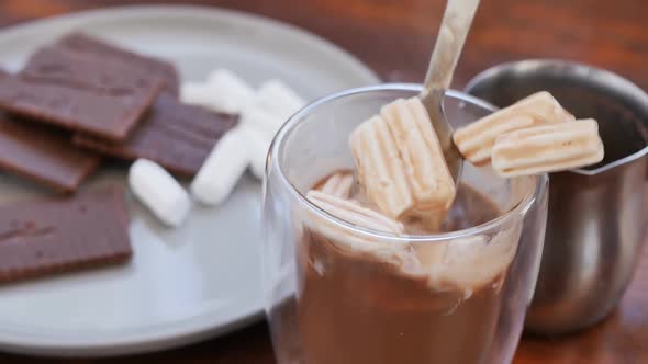 a Woman's Hand Stirred Cocoa and Marshmallows in a Glass Glass with a Spoon and Took the Glass From