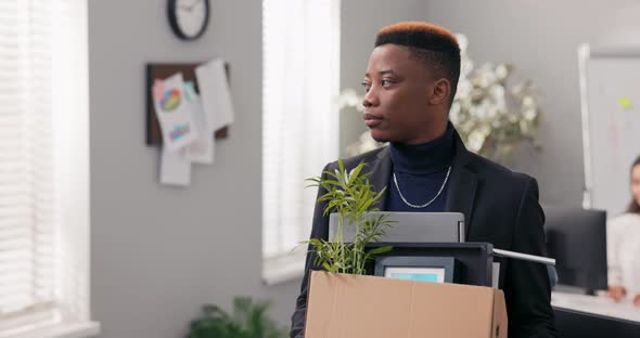 Men is Promoted to a New Position Standing in the Middle of the Office Boy Holds Cardboard Box with alt