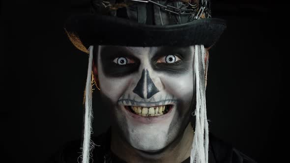 Creepy Man Face in Skeleton Halloween Cosplay Appearing on Black Background. Making Faces, Smiling alt