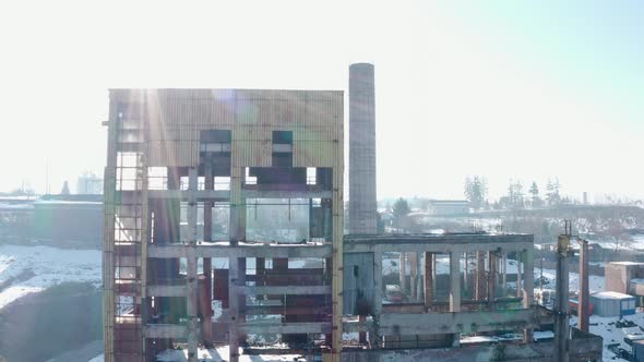 Crumbling industrial building at Vlahita with snow, Romania. Aerial pedestal up alt
