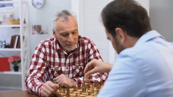 Father and Son Competing in Chess, Weekend Hobby and Leisure Activity, Tradition alt