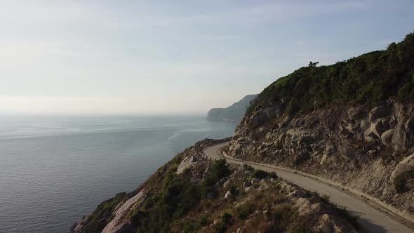 Aerial View of Spectacular Mountain Cliffside Landscape with Road on an Island alt