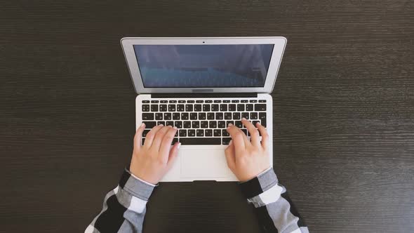 Top View of Female Hands Typing on Laptop on Black Wooden Table