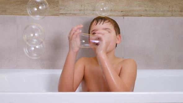 Boy Playing in Bathroom Child Bathe and Inflates Soap Bubbles alt