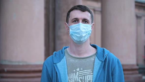 Portrait of a Man on the Streets in the Daytime Wearing a Medical Mask