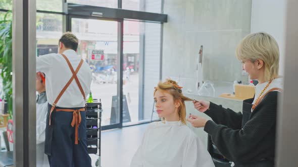 Asian professional hairdresser team giving a beauty salon service to young customer at barber shop. alt