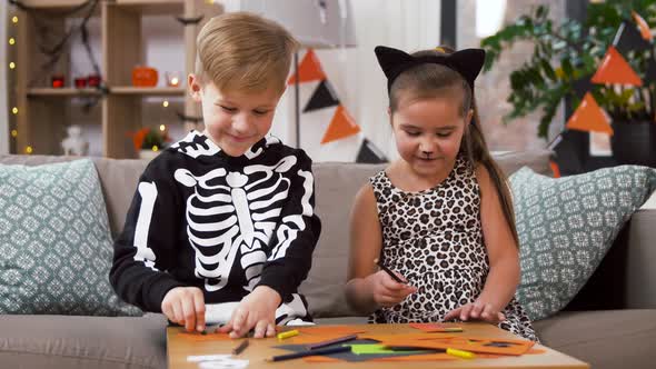 Kids in Halloween Costumes Doing Crafts at Home alt