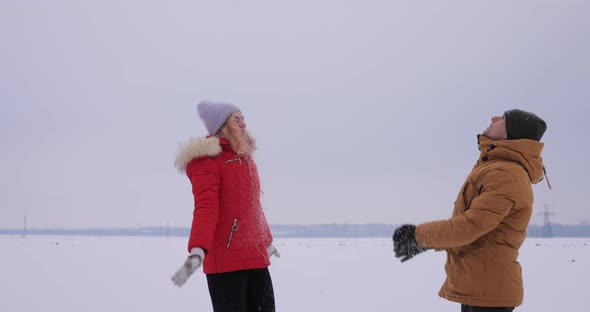 Young Couple Throwing Snow in Slow Motion alt