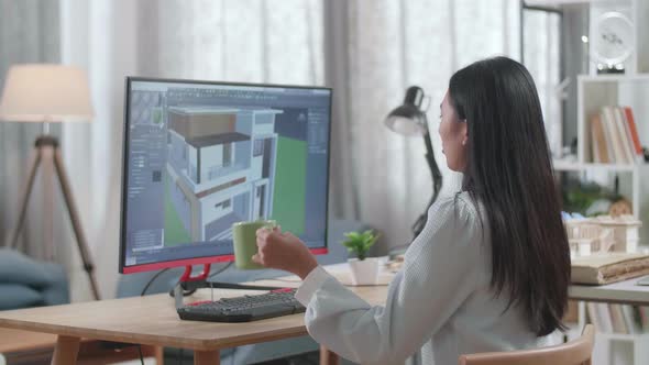 Asian Woman Engineer Drinking Coffee While Designing House On A Desktop At Home alt