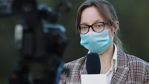 Breaking News, During Coronavirus Pandemic. Female Reporter with Medical Mask Speaking Into alt