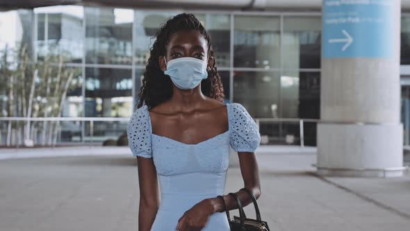 Woman in High Heels Walking Towards Camera with Empty Airport in the Background alt