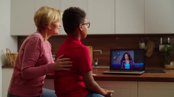 Rear View of Grandma and Multiethnic Boy Making Online Video Call at Home alt