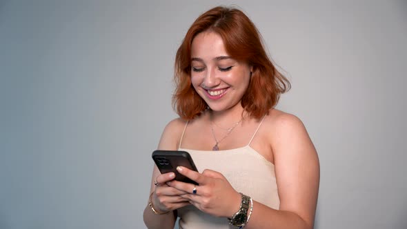 Young Woman Smiling While Texting On The Phone alt