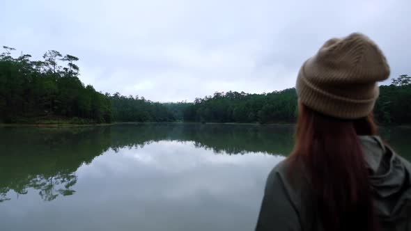 Slow motion of a young  woman looking at the lake