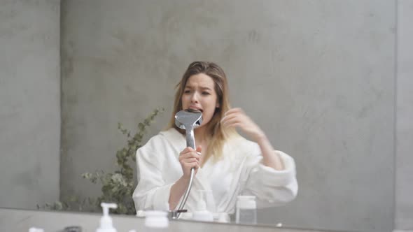 Happy Woman Singing in Bathtub Using Shower Head Having Fun Alone After Shower