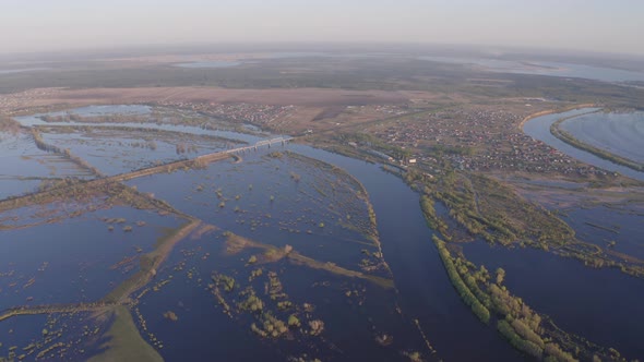 Aerial Drone Footage of a Freight Train Passes a Bridge in High Water