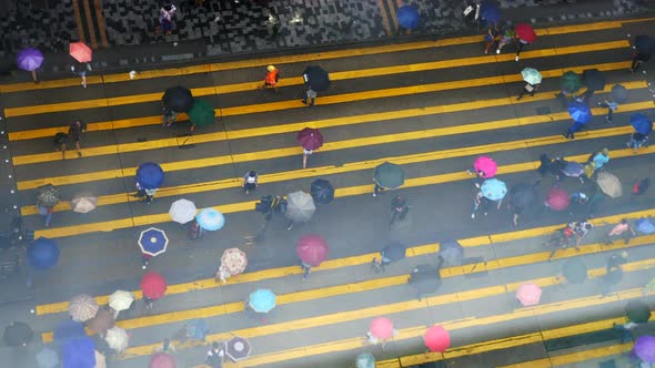 The messy of people are crossing the road in the rainy day of Hong Kong. alt