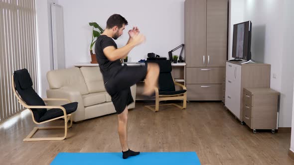 Athletic Man Kicking and Punching in the Living Room alt