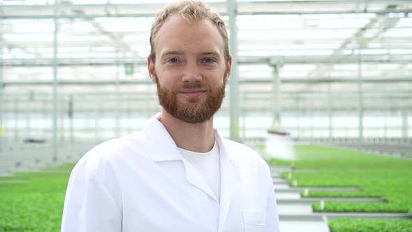 Hydroponic Greenhouse View of Young Man Posing for Camera and Smiling at Modern Farm Spbd alt