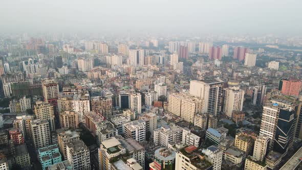 Aerial Over Dense Concrete Jungle Buildings Covered In Morning Hazy Air. Dolly Forward Establishing alt