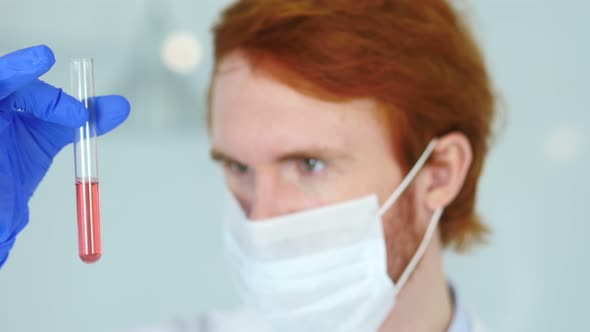Scientist Studying Red Chemical Solution in Test Tube alt