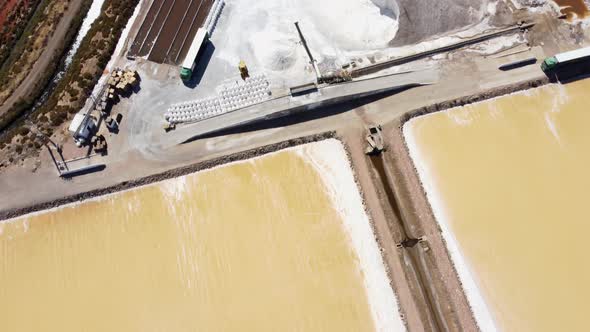 Aerial top down shot of salt farm with salt lakes and yellow salt beds in Portugal alt