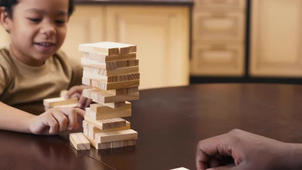 Smiling boy carefully moving Jenga blocks