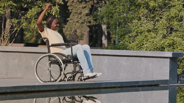 Mature African American Male Disabled in Wheelchair Waving Hands Doing Warmup Exercise Therapy alt