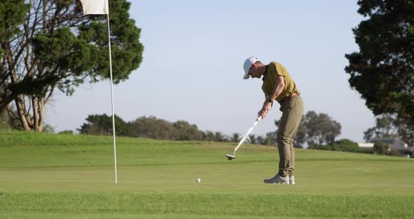 Golf player hitting the ball with his club alt