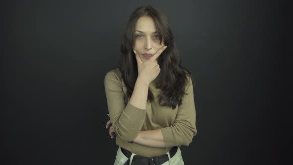 Model Plays Role of Suspicious Lady Holding Hand on Chin alt