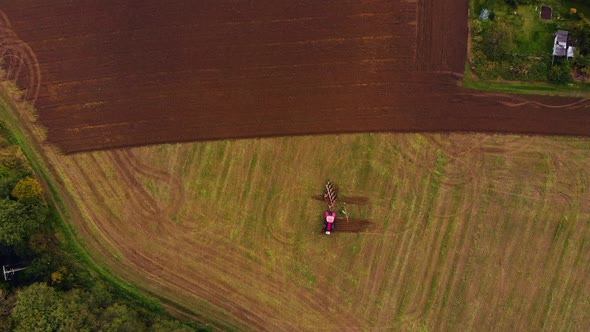 Red tractor on farm field alt