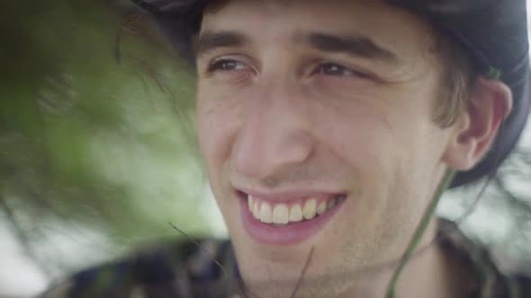 young man in explorer outfits smiles into the distance. In tropical Forest Jungle setting. alt