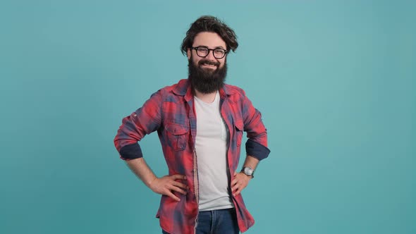 Portrait of Smiling Bearded Man Pointing at You Over Turquoise Background alt