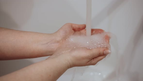 Cinematic Water Pours Through Hands at Home Water in the Bathroom From the Tap is Pouring Through