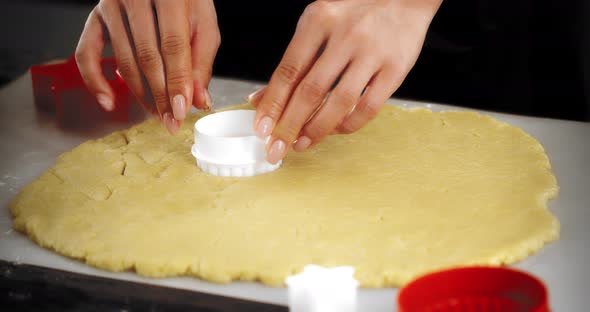 Women's Hands Squeeze Out a White Round Mold on a Shortbread Dough