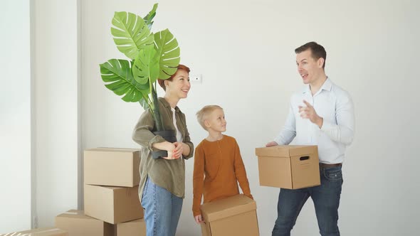 Mortgage Family and Real Estate Concept Happy Mother Father and Little Son with Stuff in Boxes