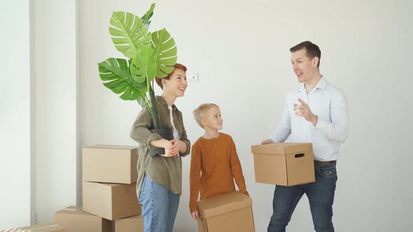 Mortgage Family and Real Estate Concept Happy Mother Father and Little Son with Stuff in Boxes alt