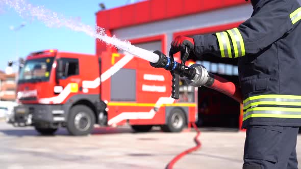  A fireman keeps fire hose for training. Slow motion and close up shot. Fire station background. alt