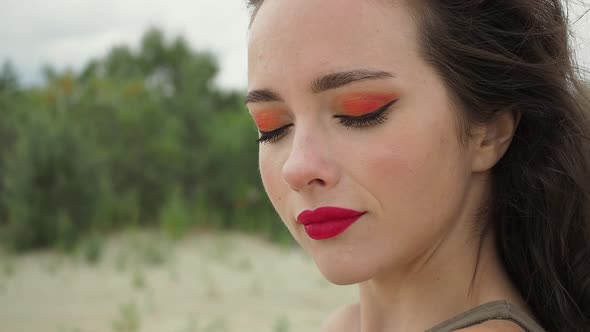 Pretty Woman Touching Hair on Beach alt