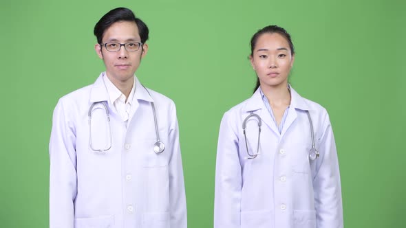 Young Asian Couple Doctors Giving Handshake Together