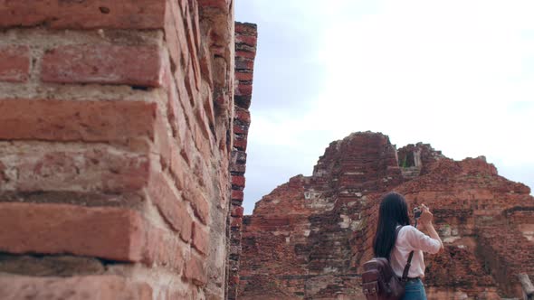 Asian woman using camera for take a picture while spending holiday trip at Ayutthaya, Thailand