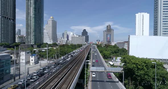 backwards aerial shot of the busy traffic on Saphan Taksin. alt