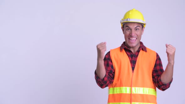 Young Happy Hispanic Man Construction Worker Touching Something and Getting Good News