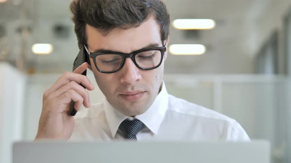 Businessman Talking on Phone at Work alt