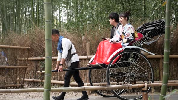Tourists Enjoying a Rickshaw Ride at Arashiyama Bamboo Forest in Kyoto Japan alt